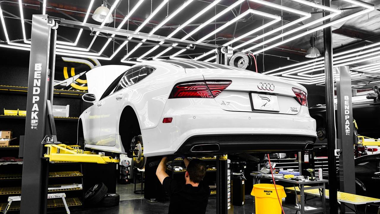 A clean service bay with a car raised on a lift