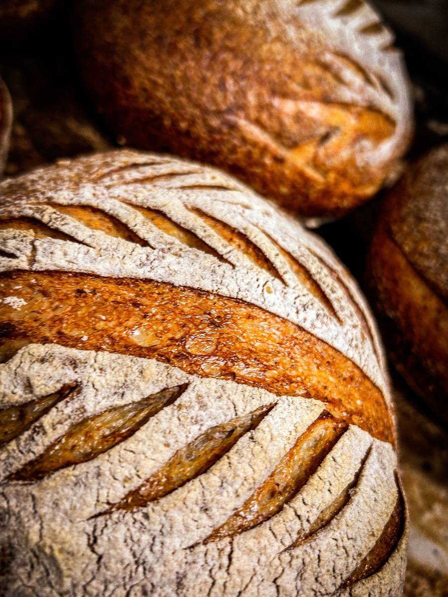 A scored sourdough loaf with a deep golden crust, fresh from the oven