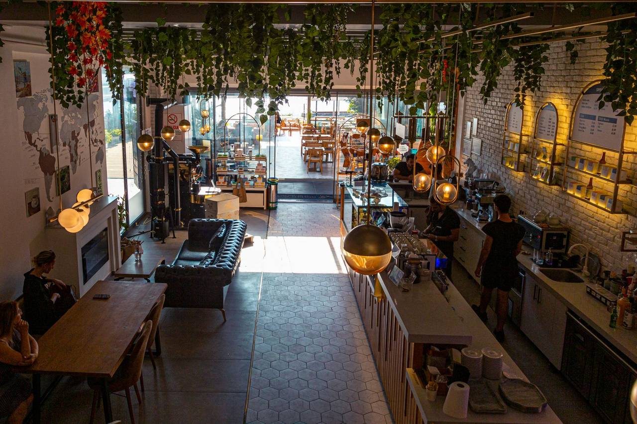 Inside the café: wooden tables, warm light and a long counter