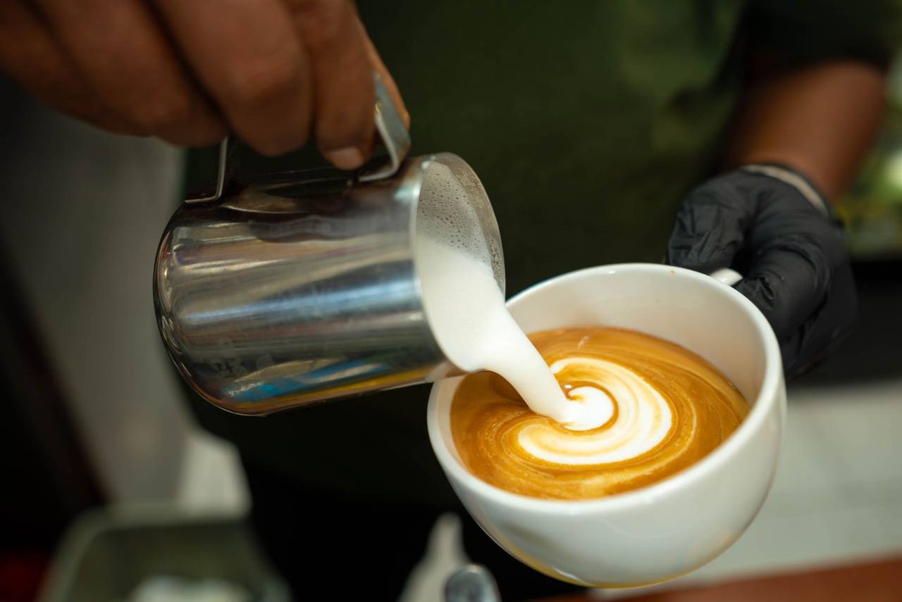 Latte art being poured into a ceramic cup