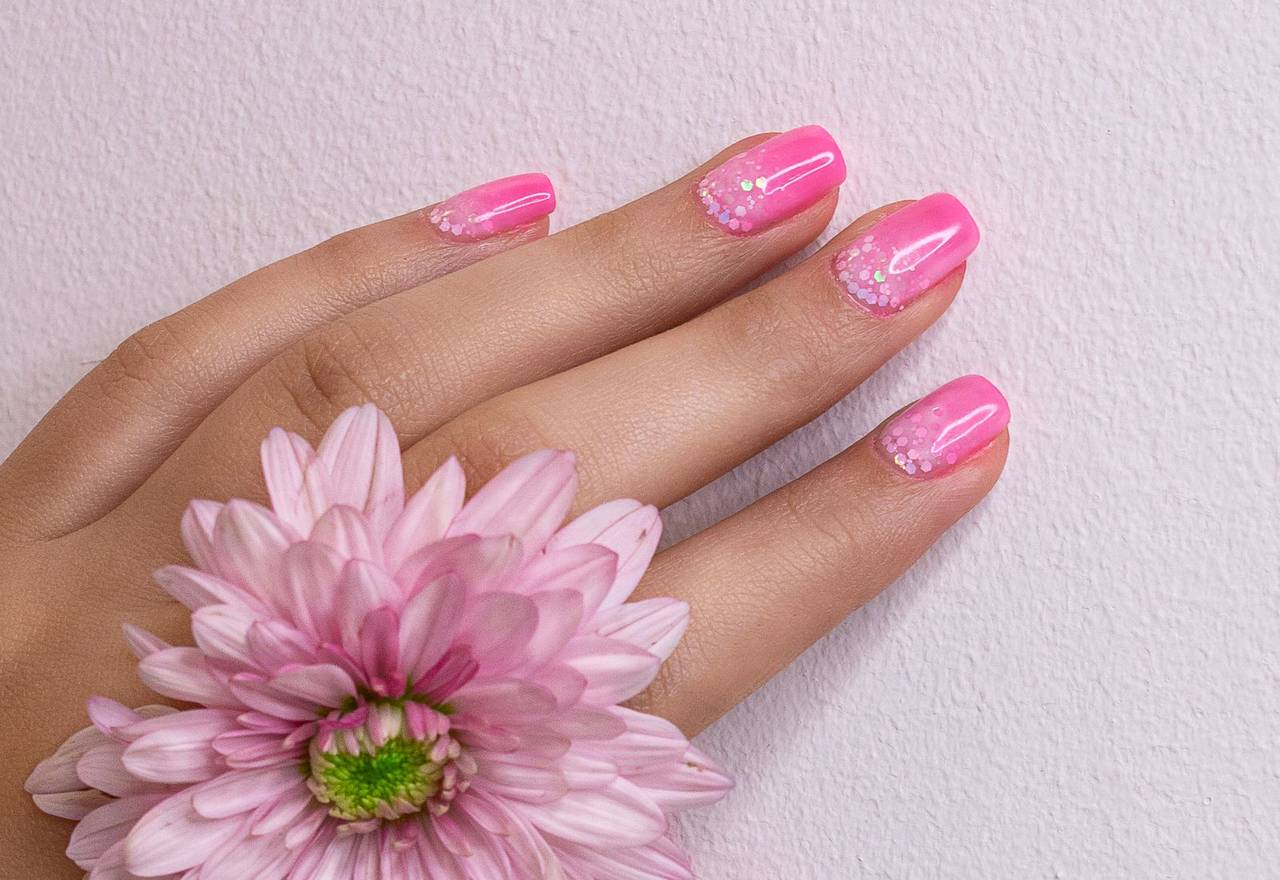 Pink nails holding a fresh flower