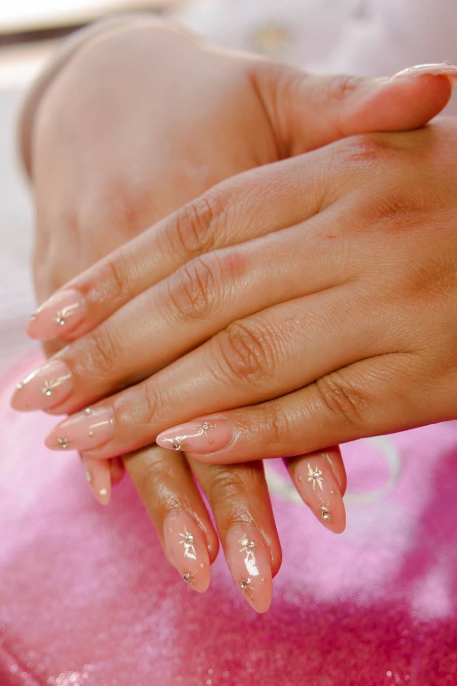 Soft nude almond nails holding a coffee cup